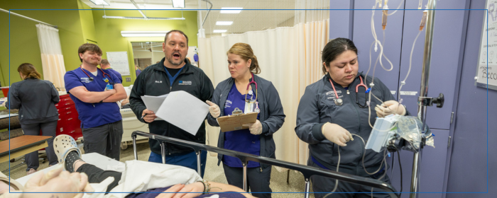 Nursing students working with medical equipment during a clinical simulation